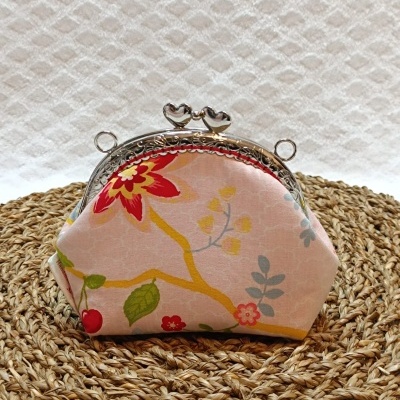 Carteira rosa com padrão floral e fecho metálico em forma de corações