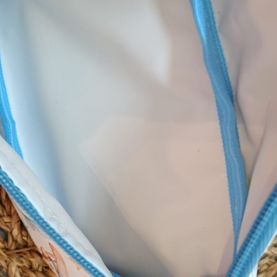 Interior de bolsa branca com fecho azul e parte exterior em tecido trançado castanho