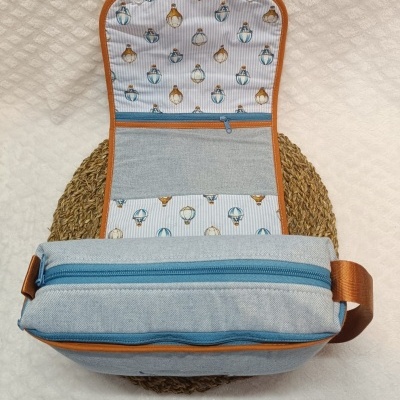 Bolsa cinzenta com padrão de balões coloridos no interior e fecho azul