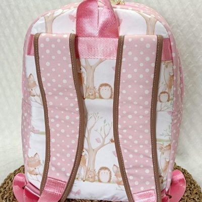 mochila infantil rosa com padrões de bolinhas e animais da floresta