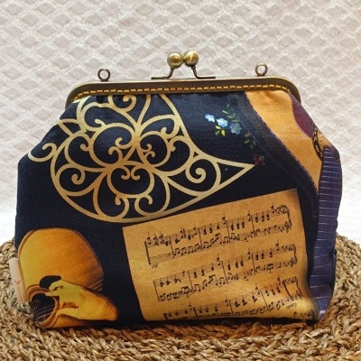 Carteira de tecido com padrão musical e decorativo, fecho metálico dourado