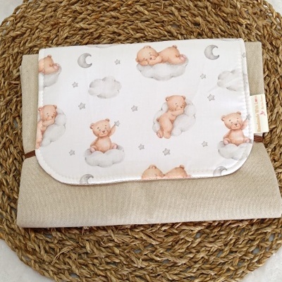 Bolsa bege com aba branca estampada com ursos, nuvens e lua sobre base de corda entrelaçada