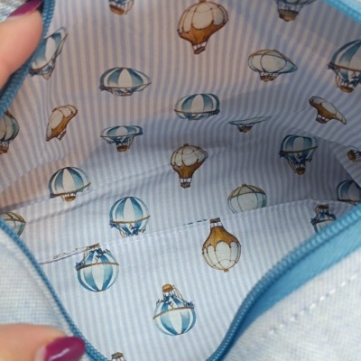 Interior de bolsa com tecido estampado de balões e riscas azuis