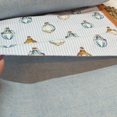 Tecido azul claro com padrão xadrez e bainha interior com padrão de balões de ar quente.