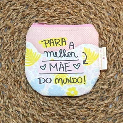 Bolsa pequena rosa com texto para a melhor mãe do mundo, sobre tapete de corda trançada.