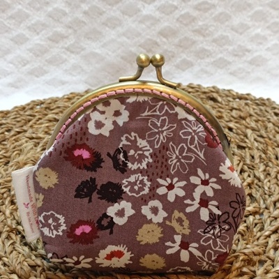 Carteira pequena com fecho metálico e padrão floral castanho