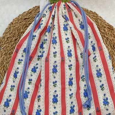 Saco de tecido com riscas vermelhas, flores azuis e cordão azul