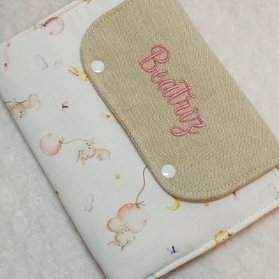 Capa ou estojo de tecido bege e branco com padrão de coelhos e nome bordado Beatriz