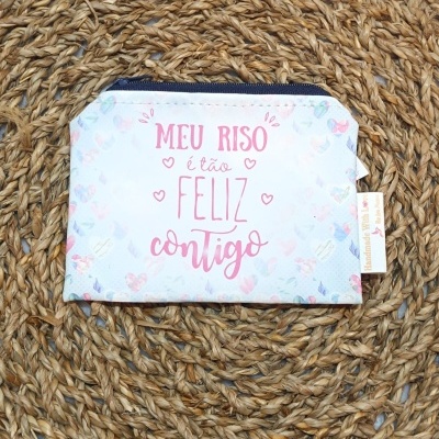 Carteira branca com texto rosa sobre superfície trançada de corda