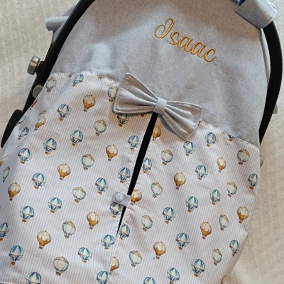 Capa para ovo de bebé com padrão de balões de ar quente e nome bordado Isaac