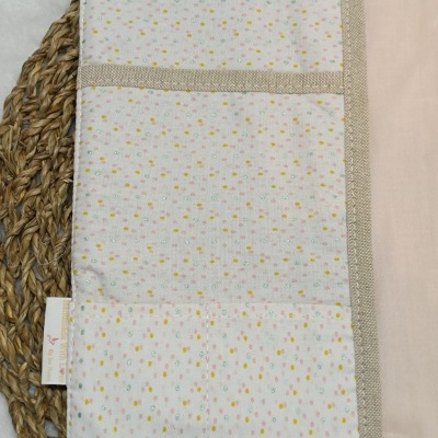 Porta-objetos em tecido com padrão de bolinhas coloridas e detalhes em fita bege