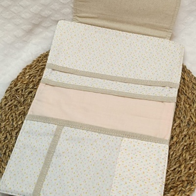 Organizador de tecido com pequenos pontos coloridos, divisórias internas e botões rosa