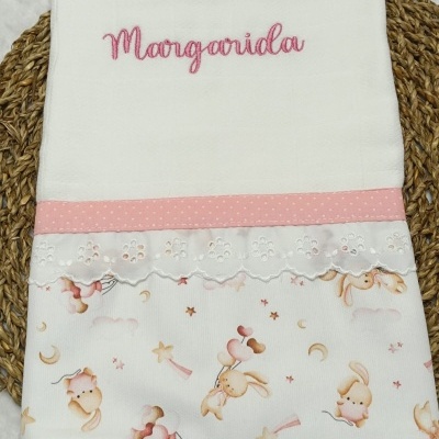 Toalha personalizada branca com bordado rosa, faixa rosa com bolinhas e estampa de coelhos.