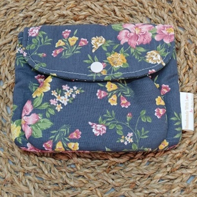 Carteira azul escuro com flores coloridas e fecho de botão branco