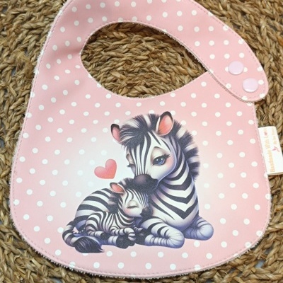 Babete rosa com bolinhas brancas e zebras abraçadas.