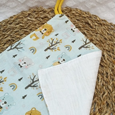 Pano macio para bebé com estampado de ursos coloridos e pega amarela.