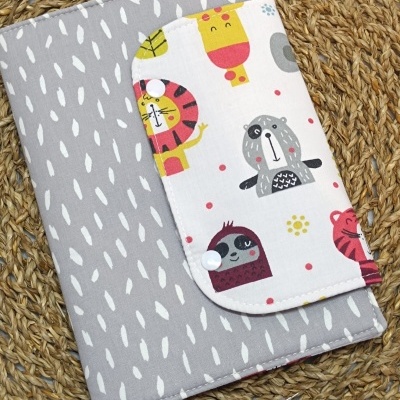 Capa de tecido com padrão de animais coloridos sobre base trançada