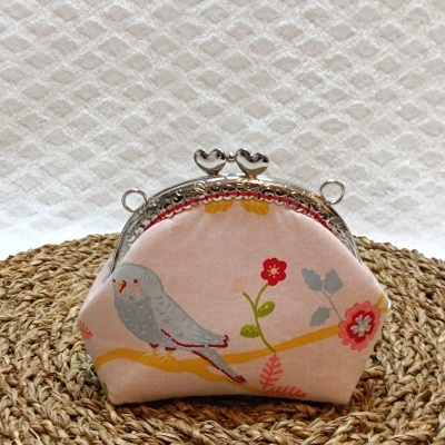 Carteira pequena rosa com estampa de pássaro e flores, fecho metálico com corações.