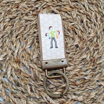 porta-chaves com ilustração de homem e crianças sobre superfície trançada
