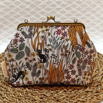 Carteira com padrão floral colorido e imagens de gatos pretos