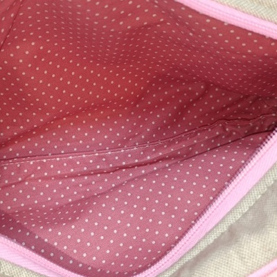 Interior de bolsa rosa com padrão de pontos e zíper rosa