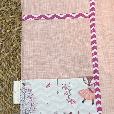 Toalhete de tecido rosa com bolso estampado e fita decorativa roxa