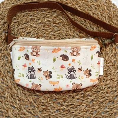 Bolsa pequena bege com padrão de animais de floresta e alça castanha