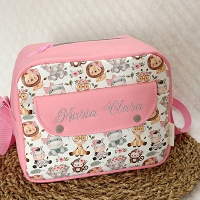 Mala rosa com padrão de animais caricaturais e nome Maria Clara bordado