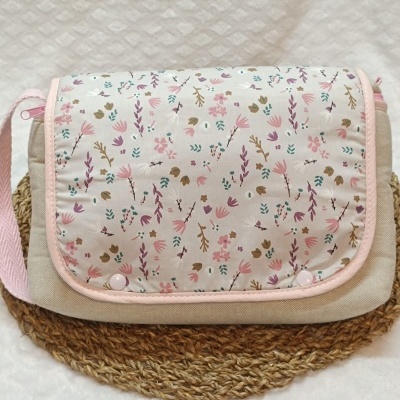 Mala pequena com padrão floral em tons rosa e lilás com alça rosa