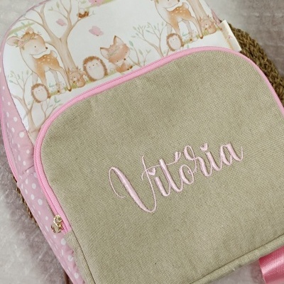 Mochila infantil rosa com bolso bege bordado e ilustrações de animais