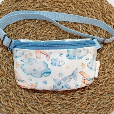 Bolsa pochete com padrão de nuvens, estrelas e aviões em azul e laranja com fecho azul