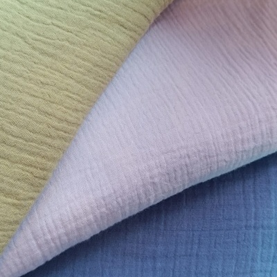 Três tecidos de algodão com textura frisada em cáqui, branco e azul.