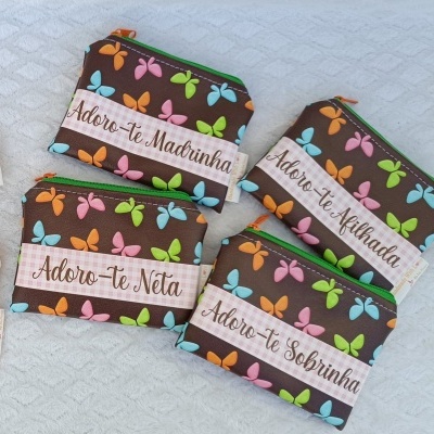 Quatro bolsas coloridas com borboletas e texto em português.