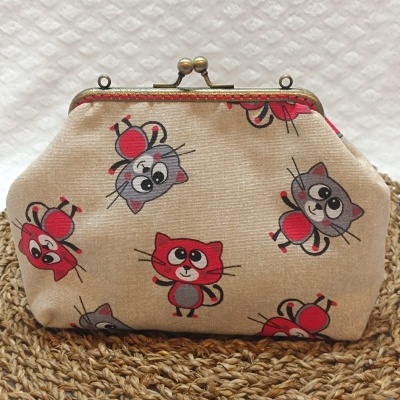 Bolsa bege com estampado de gatos coloridos e fecho metálico dourado