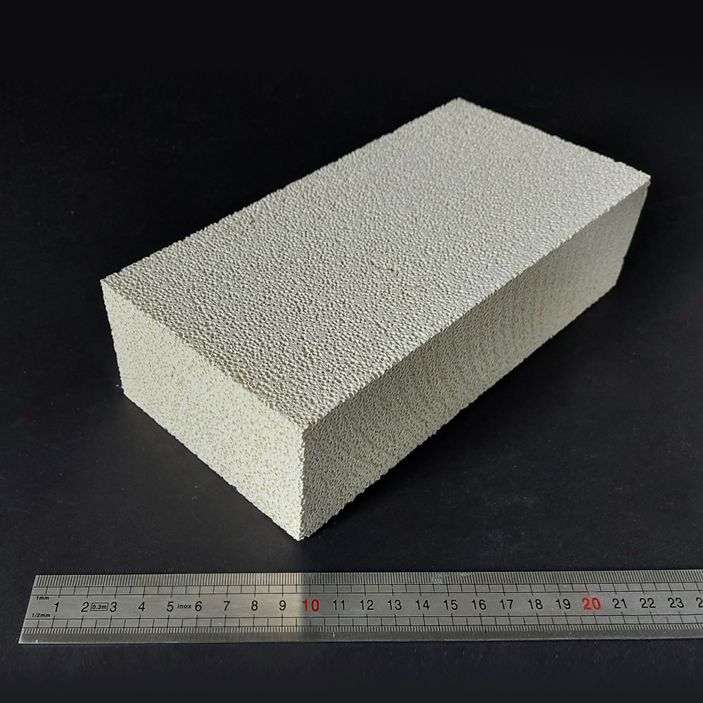 Tijolo Isolante ligeiro 1430°C DJM26 Bloco retangular branco texturizado com régua metálica para escala.