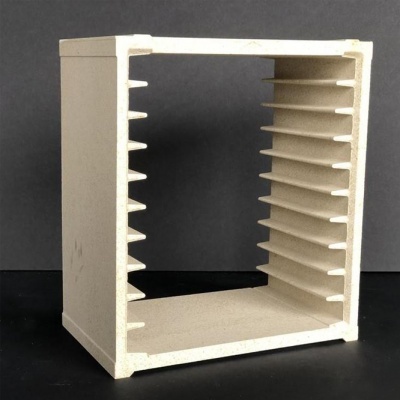 Estrutura quadrada bege com prateleiras internas estreitas sobre superfície preta