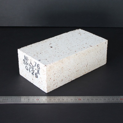 Bloco retangular branco com texto impresso e régua metálica ao lado