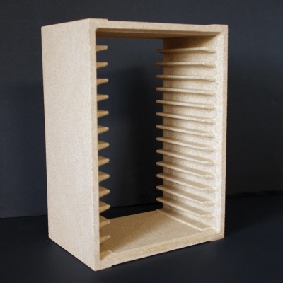 Caixa retangular castanha clara com ranhuras horizontais internas, em fundo preto