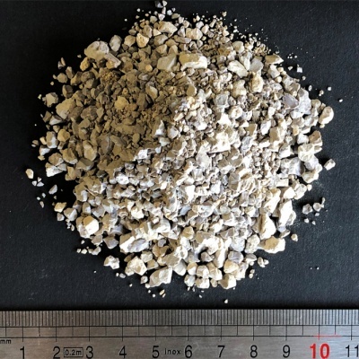 Material granuloso cinzento claro com régua em fundo preto