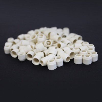 Pequenas peças cilíndricas brancas sobre fundo preto