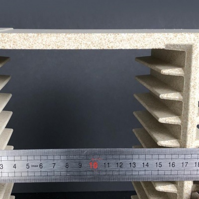 Peça creme com textura tipo pedra e régua metálica em fundo cinzento