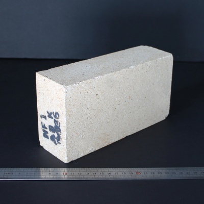 Bloco retangular branco poroso com texto manuscrito e régua metálica