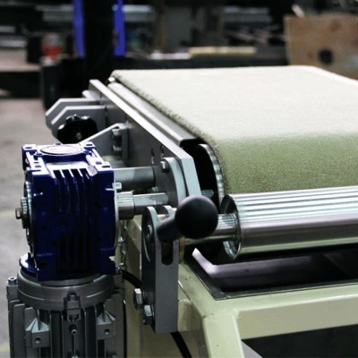 Passador industrial com correia verde e motor azul num ambiente de fábrica