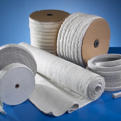 Rolos de tecido e cordões brancos com textura sobre superfície azul