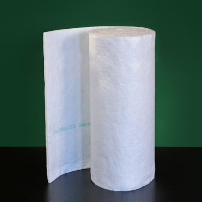 Rolo branco têxtil não tecido sobre superfície escura com fundo verde