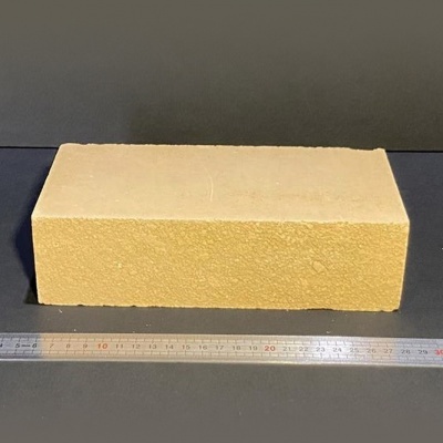 Tijolo amarelo claro com textura rugosa e régua metálica ao lado