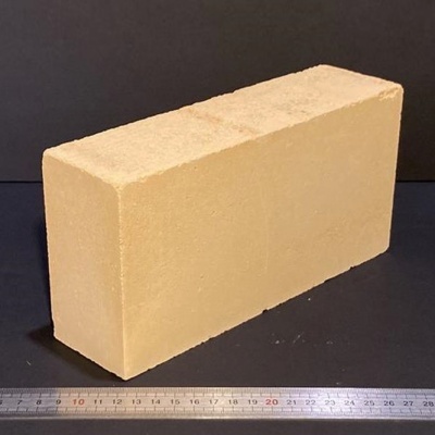 Bloco retangular bege claro sobre superfície preta com régua metálica