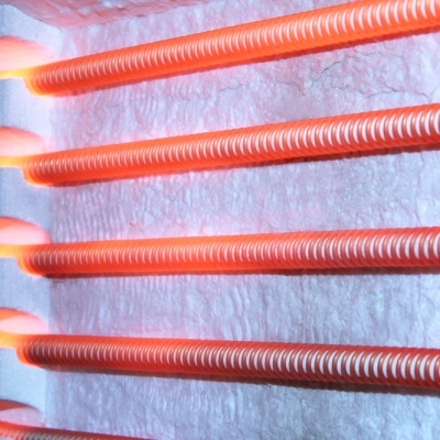 Barras metálicas vermelhas aquecidas num suporte branco texturizado