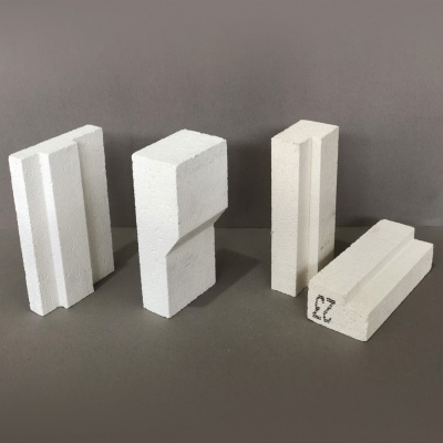 Quatro blocos brancos com textura porosa sobre superfície cinzenta, um com número 23