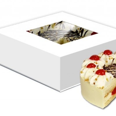 Bolo redondo com creme branco, cerejas e chocolate junto de caixa branca com janela para mostrar bolo